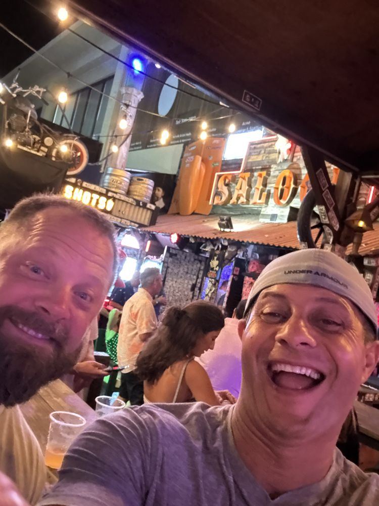 Rob and a friend laughing at a saloon bar