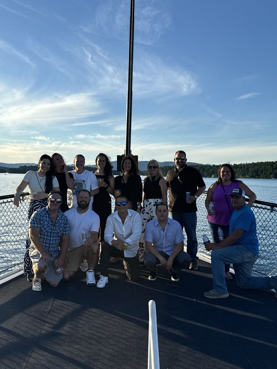 A group of friends on the bow of a boat at sunset on the lake
