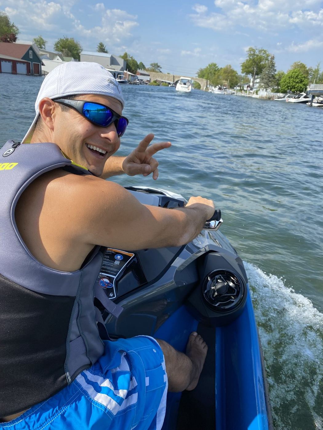 Rob on a jet ski in the Weirs channel flashing a peace sign