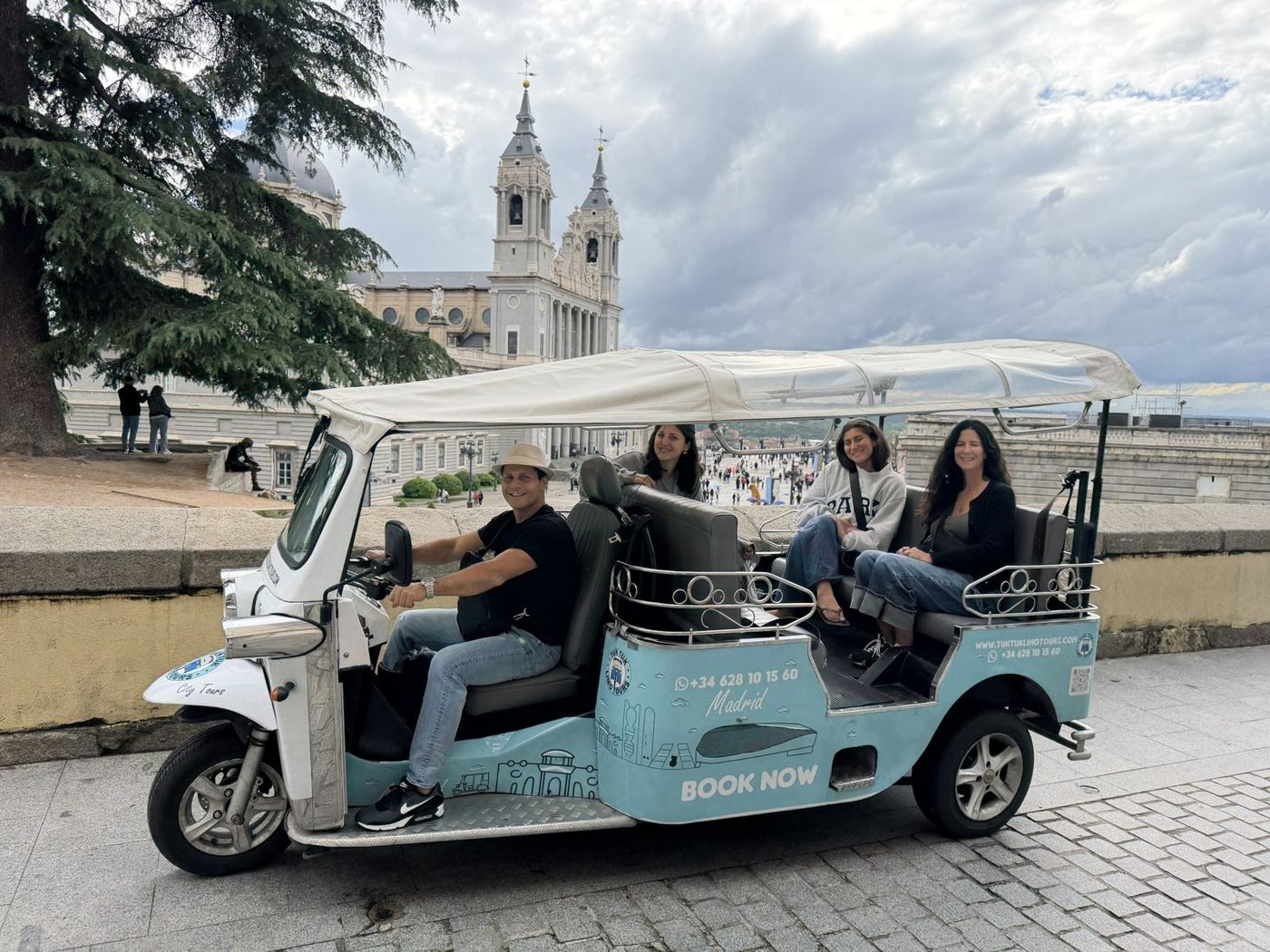 The family in a tuk-tuk in front of Almudena Cathedral, Madrid